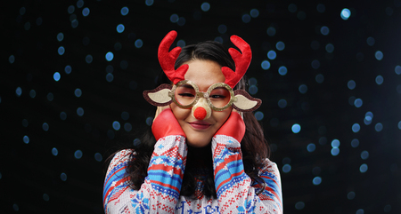 Asian Girl Wearing Christmas Sweater and Christmas Reindeer Glasses Red Noseの写真素材
