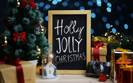 Holly Jolly Christmas Typography on Blackboard Between Christmas Decorationの写真素材