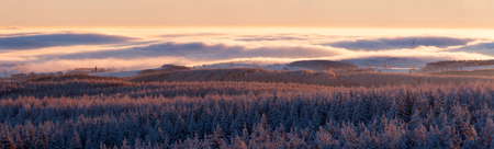 winter landscape during the sunrise with fog and a windmillの写真素材