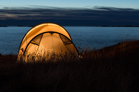 Iluminated tent in front of the Atlantic coast in Norwayの写真素材