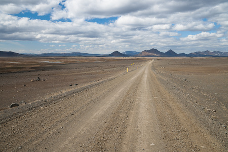 mountain road in an empty landscape in iceland at a sunny dayの写真素材