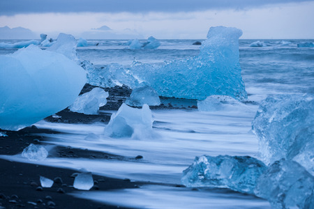 Ice floes lying on a black beach near Jokulsarlon glacier lagoon in Iceland