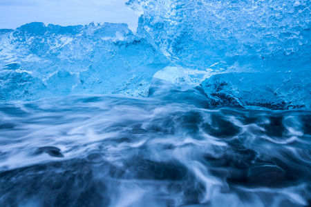 Ice floes lying on a black beach near Jokulsarlon glacier lagoon in Iceland