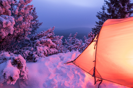 Illuminated tent in a white winter landscape at nightの写真素材