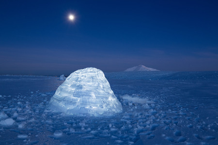 Iluminated igloo during a cold winter nights with bright moonshineの写真素材