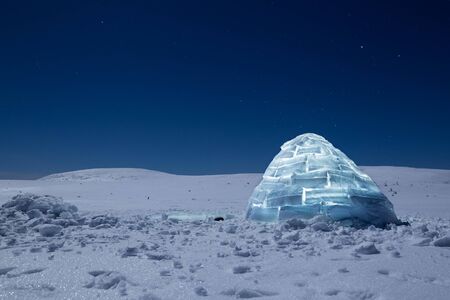 Iluminated igloo during a cold winter nights with bright moonshine