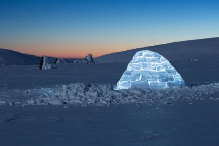 Iluminated igloo during a cold winter nights with bright moonshineの写真素材