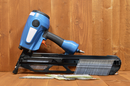 pneumatic air nail gun wood background tableの写真素材