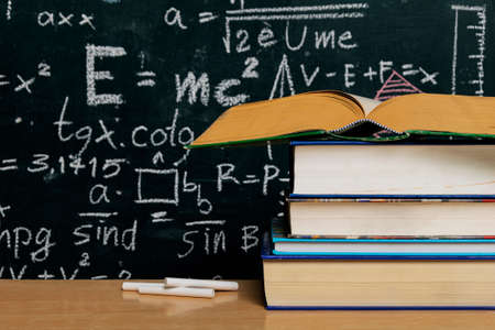 Open book and school supplies on the table in classroom with blackboard background, back to school concept, back to school conceptの写真素材