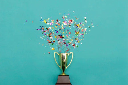 Celebrating the success that has happened, Gold trophy placed on a blue background. There are gift boxes and colorful ribbons.の写真素材