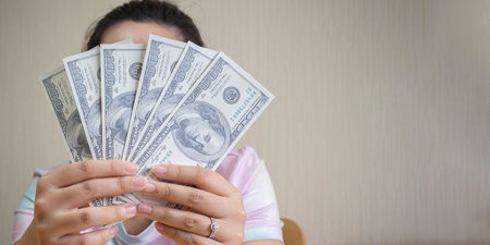 Woman with dollars in hand and space for text. Girl holding cash money in dollar banknotes. Woman holding lots of money in dollar currency. Luxury, beauty and money conceptの写真素材
