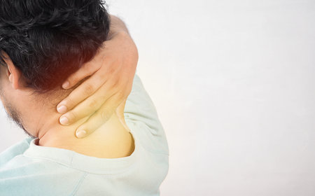 Close up of man with neck pain, a man with neck pain on isolated background, neck pain and stress concept, man with muscle pain.の写真素材