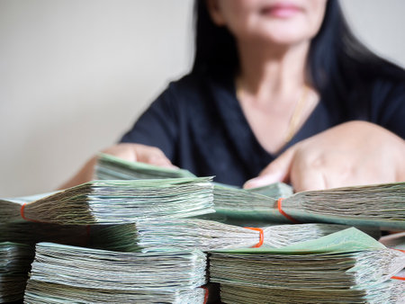 Asian business woman counting money cash in office.  Businesswoman recount money banknotes at workplace. Smiling woman receiving salary in cash.の写真素材