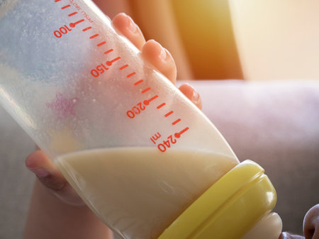 Crop of image Asian baby boy drinking milk from bottle and lying  the sofa in home with soft light behide. Baby and Mom concept.の写真素材