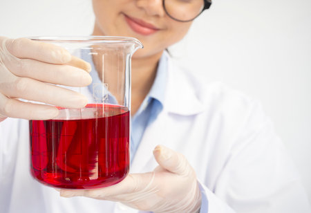 Close up of young female scientist with flask making test or research in clinical laboratory. Science, chemistry, biology, medicine and people concept.の写真素材