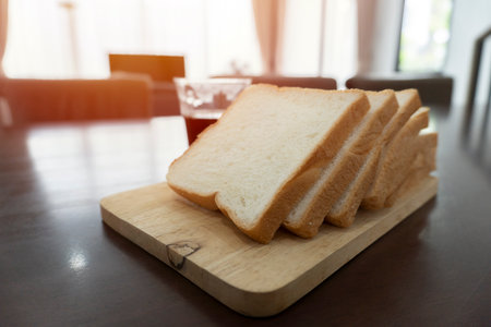 Wooden board with tasty breakfast toasts on table, slice hole wheat bread breakfast in morning. Cooking and eating with healthy lifestyle.の写真素材