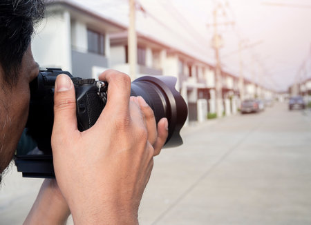Close up hands of Young Asian photographer taking pictures of housing estates. Property and real estate concept.の写真素材
