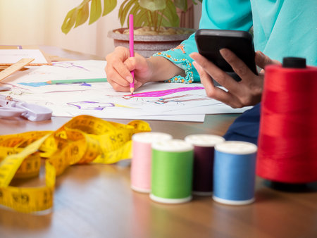 Small business of Muslim woman fashion designer Working and using smart phone and tablet With Dresses at clothing storeの写真素材