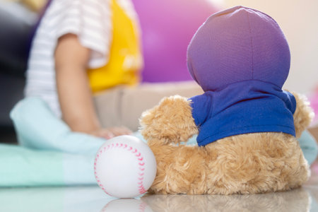 Toddler sitting on the floor of living room with big window at sun set. Kids play indoors. Kid and stuffed animal at home.の写真素材