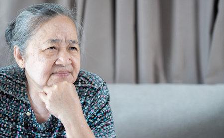 Senior Asian grey-haired woman wearing casual clothes skeptic and nervous, disapproving expression on face.  Mistrustful, confused, shy, trustless, scared, evil person.の写真素材