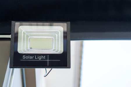 LED spot light and solar panel on wall outside of the house with sunshine. A ceiling spot light install on a house beam.の写真素材