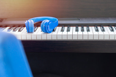 Headphones on musical synthesizer keyboard. Scene of relaxing in living room with morning light...