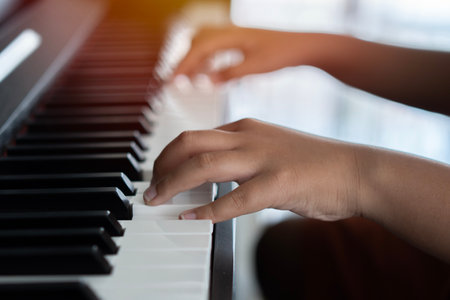 Hands of the child on the piano keys. Selective focus. Music abilities for kids. Hobby and activity for the children concept.の写真素材