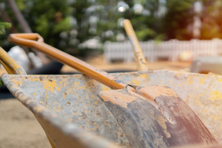 Two-wheeled wheelbarrow loaded and a square-point spade on the cultivated area in the autumn garden under reconstructionの写真素材