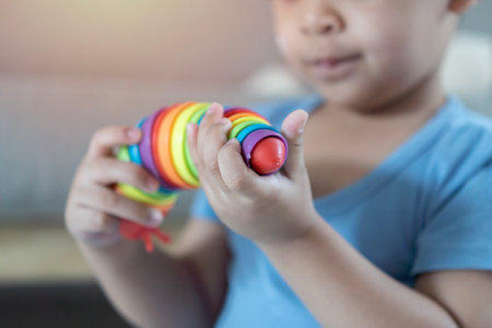 Cute little boy playing with colorful toys on floor at home. Evolution and paleontology game for...