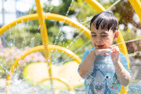 Portrait of little Asian cute boy enjoying day trip to an aqua amusement park during summer family vacation. Family vacation concept.の写真素材