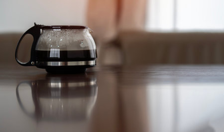 Close-up of electric glass coffee pot is on the wooden table for preparing breakfast with morning...