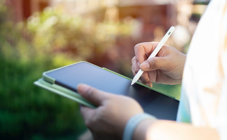 Closeup, Success company manager using digital tablet for making business schedule from home, male holding stylus pen and tablet.の写真素材