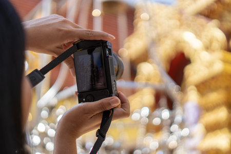Hands of Asian woman tourist backpacker traveling and taking photo with temple background in Thailand. Thai Tourism and photographer conceptの写真素材