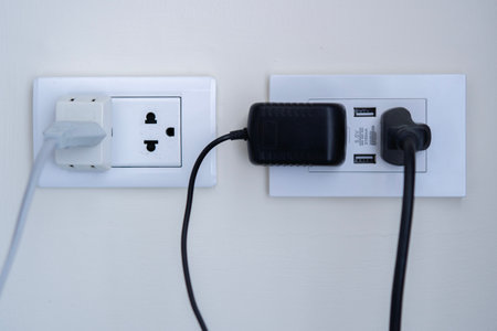 Multiple socket with connected plugs or power plug connected to wall outlet in room on a white...