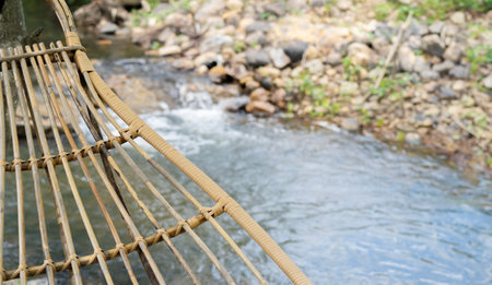 Cropped image of bamboo hammock hanging in the garden yard nearby the waterfall for relaxing in the summer. Travel and rest concept. copy space.の写真素材