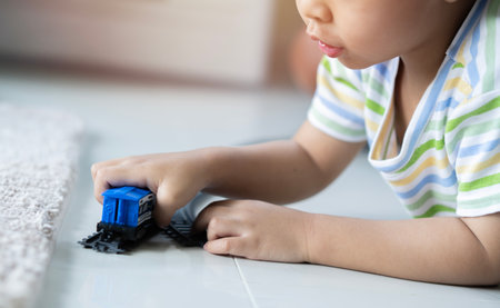 Cute little Asain boy playing with colorful toys on floor at home, space for text, selecitve focus.の写真素材