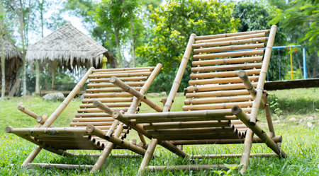 A set of bamboo chairs. Two chairs on a nature background. Country style bamboo bench in garden....