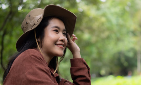 Attractive girl traveler look around and explore while sitting in nature wood with happiness and fun during holiday vacation trip.の写真素材