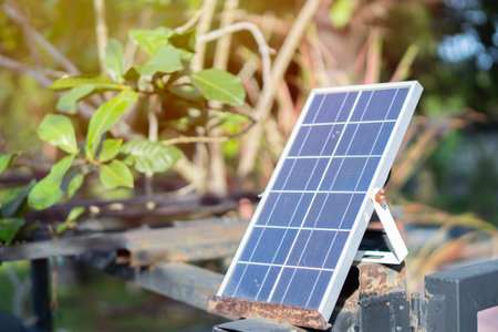 Selective focus of mini stand electric solar cell in garden and warm sunlight on background. Saving...
