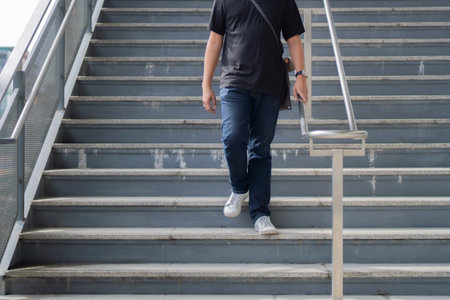 Cropped image of man walking down stairs. Exit subway. Passengers go down stairs from subway....