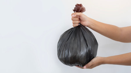 Woman hands holding garbage bag isolated on white background. Waste management concept, copy space.の写真素材