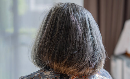 Back view of senior mature middle aged older Asian lady with short gray natural coloring vibrant silky hair. Close up. Hairstyle.の写真素材