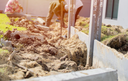 Soft focus of worker digs soil with spade prepare around pole stucture in construction site. Digging soil concept.の写真素材