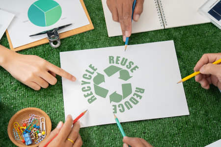 Cohesive group of business people pointing in environmental awareness symbol as eco corporate...