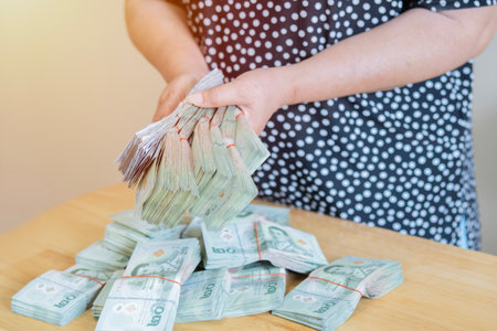 Shot of Asain woman hands holding and counting baht banknote, Stacked of cash 20 baht banknote....