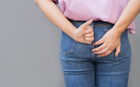 Close up of healthy woman touching her bottom and showing thumb up sign for good digestive, healthy...