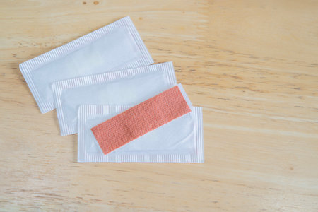 Top view image of medical equipment - adhesive plasters on wooden background. Close-up, copy space.