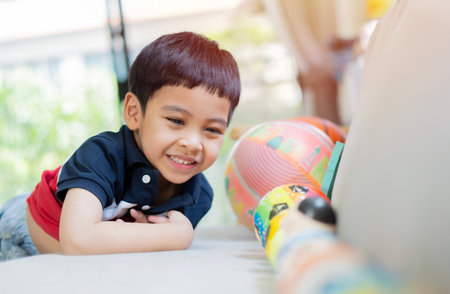 Portrait image of cute Asian child, black hair boy, playing with colofrul plastic ball at home. Selective focus.の写真素材