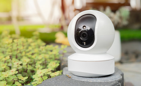 CCTV, security camera system operating with blurred image of sun light in garden background,...