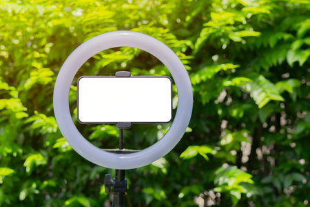 Horizontal smartphone with led ring lamp over on real nature background with copy space. Blogger...